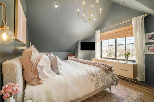 a bedroom with a bed and a window and a chandelier at Luxe Designer Flat on Sloans Lake with Rooftop Deck in Denver