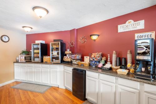 a coffee shop with a counter with food on it at Fireside Inn & Suites Gilford in Gilford