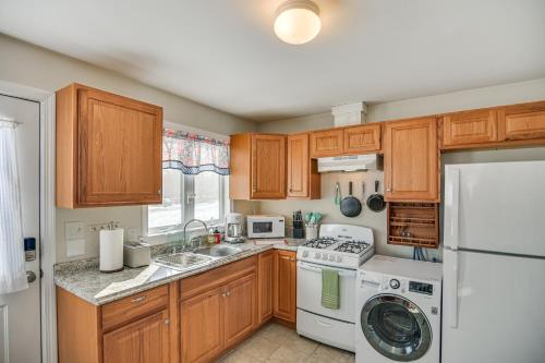 a kitchen with wooden cabinets and a white refrigerator at 9 Mi to Beach Home with Private Yard in Westport in Booth Corner
