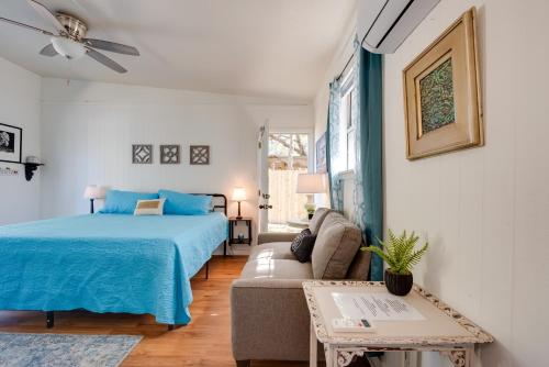 a bedroom with a blue bed and a couch at 6 Mi to St George Island Cozy Gulf Coast Retreat! in Eastpoint