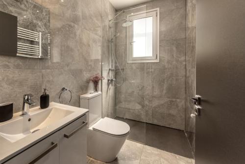 a bathroom with a toilet and a shower and a sink at Fig Tree Bay Residences 7 in Protaras