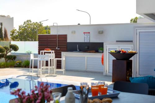 a patio with a table with a bowl of fruit at Fig Tree Bay Residences 7 in Protaras
