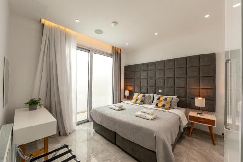 a bedroom with a large bed and a large window at Fig Tree Bay Residences 7 in Protaras