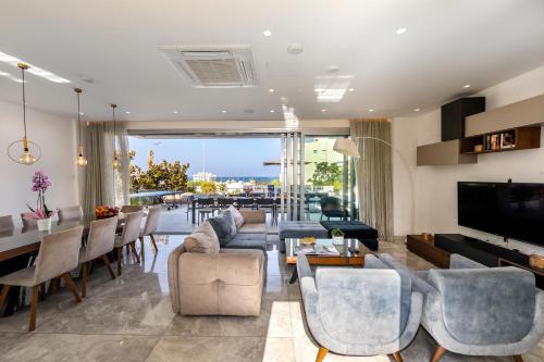a living room with a couch and chairs and a table at Fig Tree Bay Residences 7 in Protaras
