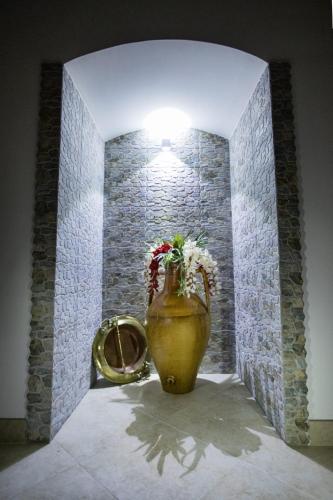 a vase with flowers in a room with a wall at Il Galante B&B casa vacanza in Ginosa