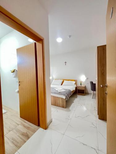 a bedroom with a bed and a door to a room at CASA della FIAMMA D'AMORE di MARIA in Međugorje
