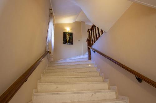 a staircase in a house with a painting on the wall at Bora Hotel in Gjirokastër