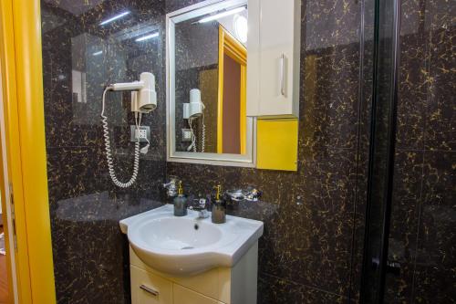 a bathroom with a sink and a shower at Bora Hotel in Gjirokastër