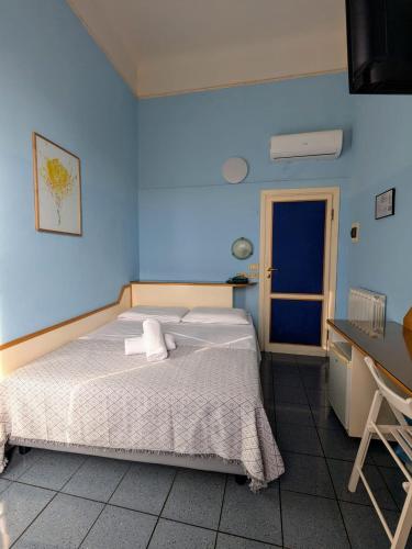 a bedroom with a bed and a blue wall at Hotel Soggiorno Athena in Pisa