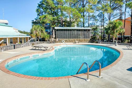 a large swimming pool with blue water in a yard at Surf Club B-9 in Dauphin Island