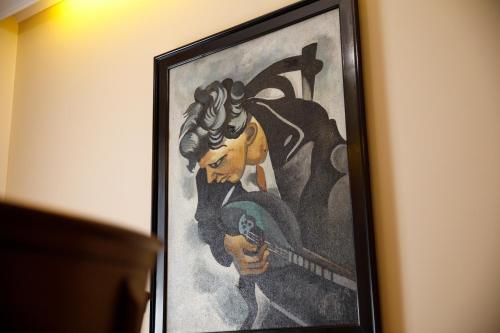 a framed painting of a woman with a sword at Bora Hotel in Gjirokastër