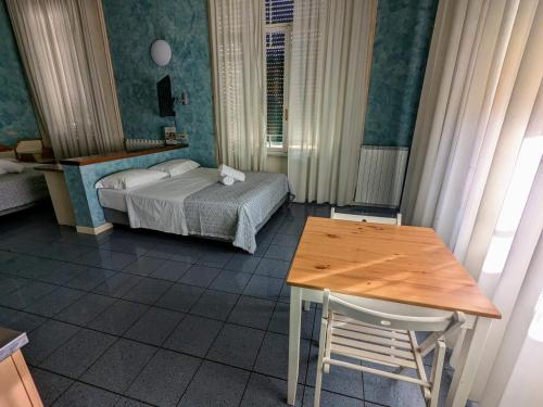 a bedroom with a bed and a table and a desk at Hotel Soggiorno Athena in Pisa