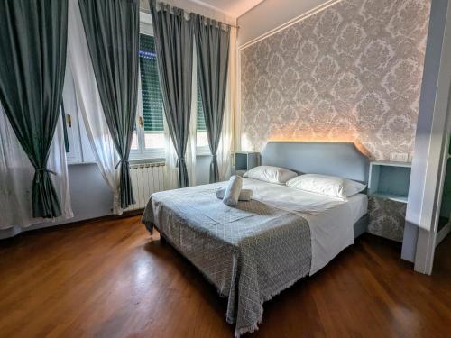a bedroom with a bed with a blue headboard and curtains at Hotel Soggiorno Athena in Pisa