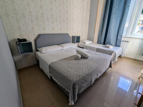 a small bedroom with two beds and a window at Hotel Soggiorno Athena in Pisa