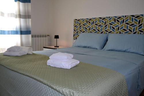 ein Bett mit zwei Handtüchern darauf in der Unterkunft La luna nel Cortile in Serradifalco