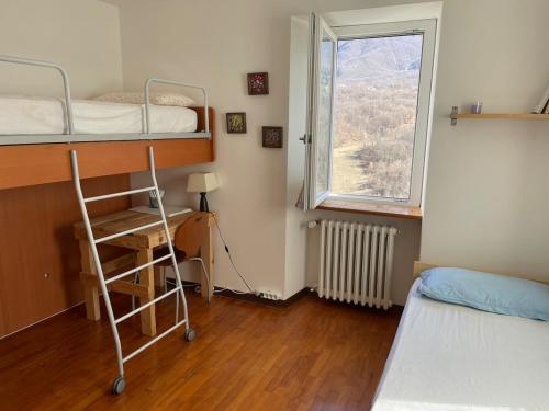 a bedroom with two bunk beds and a window at Casa CampoSelvatico in Valdena