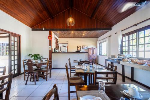a restaurant with wooden ceilings and tables and chairs at Pousada Maria Maria Búzios in Búzios