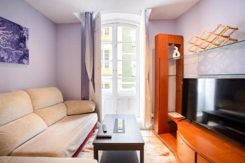 a living room with a couch and a television at La Maresía in Cudillero