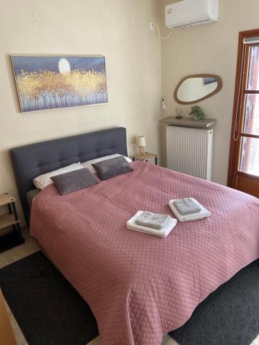 a bedroom with a pink bed with two towels on it at ZoYa ‘s Apartments in Agria
