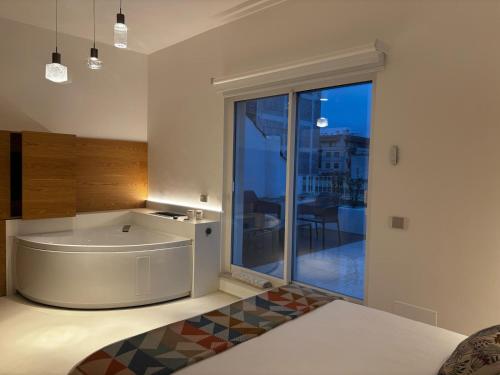 Una cocina con bañera y una gran ventana. en Atrox, en Putignano