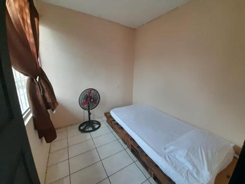 a small bedroom with a bed and a fan at Apartamentos GoZu # 2 in Puerto Viejo