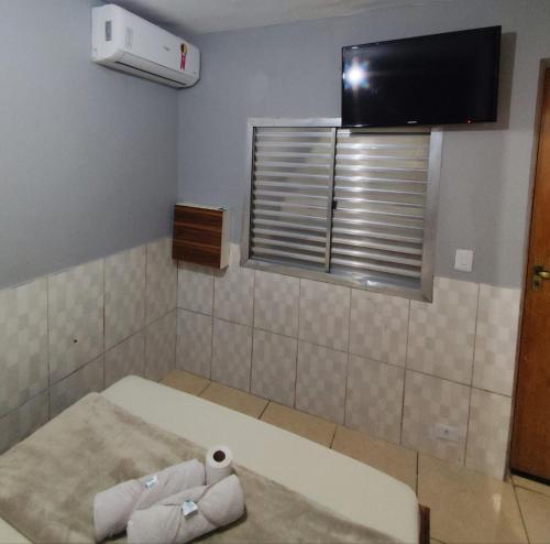 サンパウロにあるHotel xandu-proximo arena corinthiansの壁にテレビとベッドが備わる客室です。