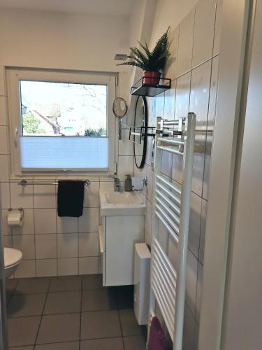 a small bathroom with a sink and a window at Apartement Seestern mit kleinem Südbalkon, 100m zum Meer in Steinhude