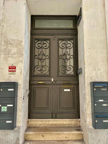 une grande porte en bois dans un bâtiment avec deux boîtes aux lettres dans l'établissement Le SILVA Centre ville Lumineux Wifi et Netflix, à Périgueux