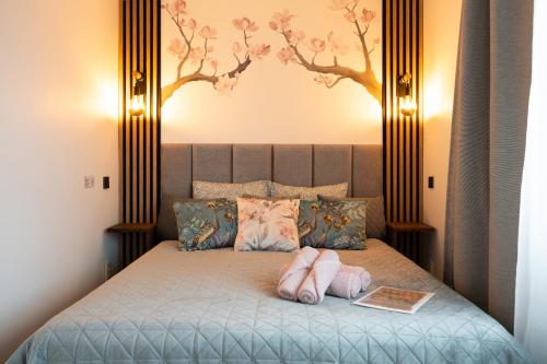 a bedroom with a bed with a tree mural on the wall at 4 Bedroom House with Playground, BBQ & Free Parking in Rīga