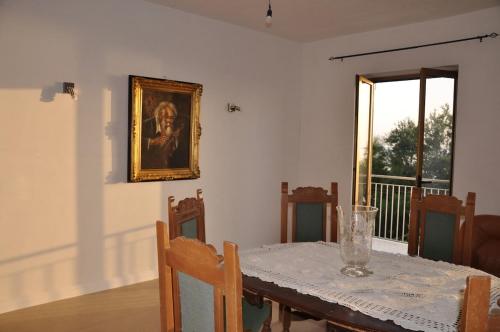a dining room with a table and a picture on the wall at Un Sogno in Riva al Mare in Belmonte Calabro