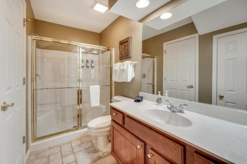 Un baño con ducha, lavabo e inodoro. en Walk to Branson Strip Inviting Condo!, en Branson