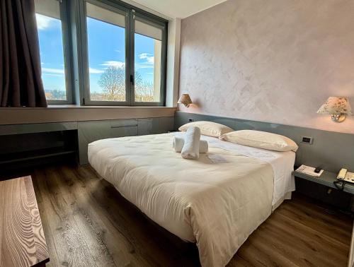 a bedroom with a bed with a stuffed animal on it at Hotel Alfieri in Sirmione
