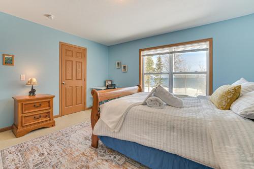 Un dormitorio azul con una cama y una ventana. en Lakefront Home with Yard and Views in Cheboygan!, en High Banks