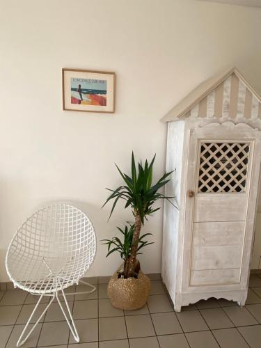 a white chair and a chair next to a door at Vue sur l'entrée du port in Saint-Gilles-Croix-de-Vie