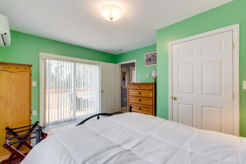 a bedroom with a white bed and green walls at Walk to Eastern Point Beach Apt with Water View! in Groton