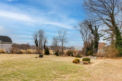 a yard with a house and trees and bushes at Walk to Eastern Point Beach Apt with Water View! in Groton