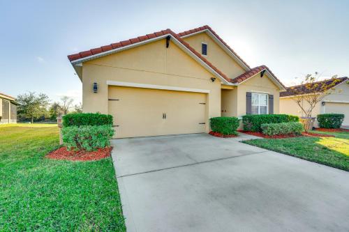 a house with a garage in a yard at 7 Mi to USTA Waterfront Tennis House with Yard! in Kissimmee
