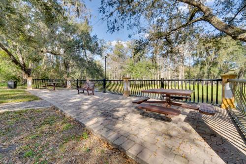 a picnic table and benches next to a fence at 7 Mi to USTA Waterfront Tennis House with Yard! in Kissimmee