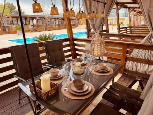 a table and chairs on a patio with a pool at Casabella Turanj in Turanj