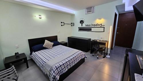 ein Hotelzimmer mit einem Bett und einem Schreibtisch und einem Schreibtisch in der Unterkunft A12 SUITE BLACK para 1 a 2 personas, Especialistas en CORTAS, MEDIANAS Y LARGAS ESTANCIAS en IZCALLI TEPOTZOTLAN perfecto para Familias, Turistas, Contratistas, Estudiantes, Empresas A sólo 5 min Izcalli 5 min Esmeralda 20 min Satélite 25 min AIFA in Municipio Cuautitlán Izcalli