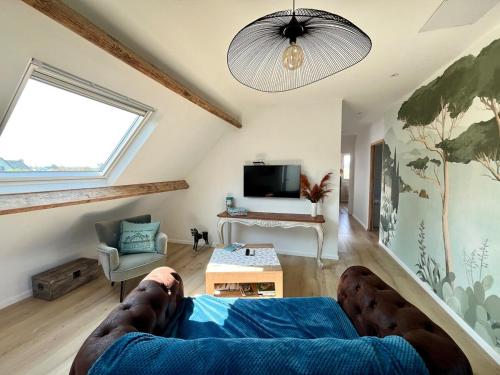 a person laying on a bed in a living room at Appartement cosy 65 m2 - PORT ES LEU - Saint Quay Portrieux in Binic-Etables-sur-Mer