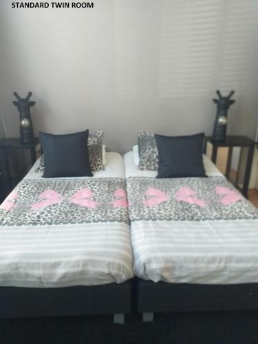 two beds sitting next to each other in a room at El Sol Zandvoort in Zandvoort