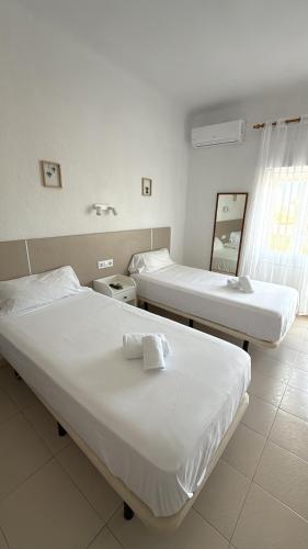 two beds in a hospital room with a mirror at Hotel Bennington in La Marina