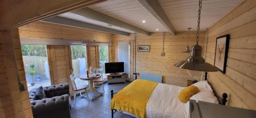 a bedroom with a bed and a desk and a television at Sea La Vie in Perranporth