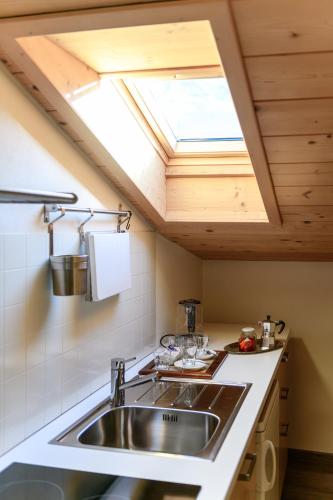 a kitchen with a sink and a skylight at Hotel Garni Le Corti in Grosotto