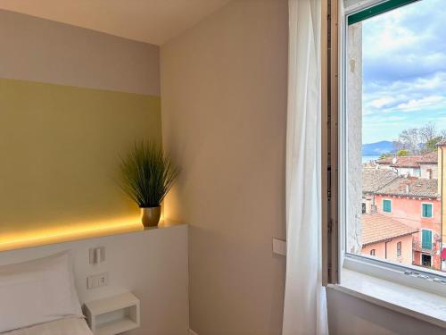 a bedroom with a window with a potted plant at Palazzo Betteloni in Bardolino