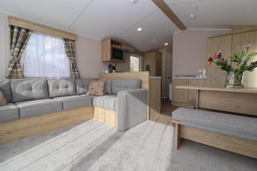 a living room with a couch and a table at The Roost - Family Friendly caravan near Glastonbury & Street in Compton