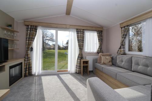 a living room with a couch and a window at The Roost - Family Friendly caravan near Glastonbury & Street in Compton
