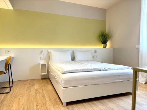 a bedroom with a white bed with a green wall at Palazzo Betteloni in Bardolino