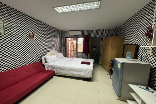 a living room with a bed and a red couch at Green Place 107 in Bangkok